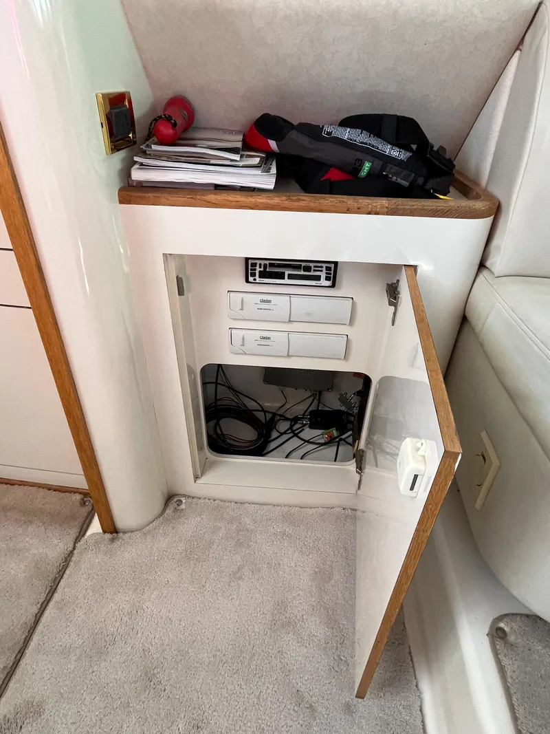 Slide: The Image of 1997 Sea Ray 420 Aft Cabin interior storage compartment with electronic controls. - 43