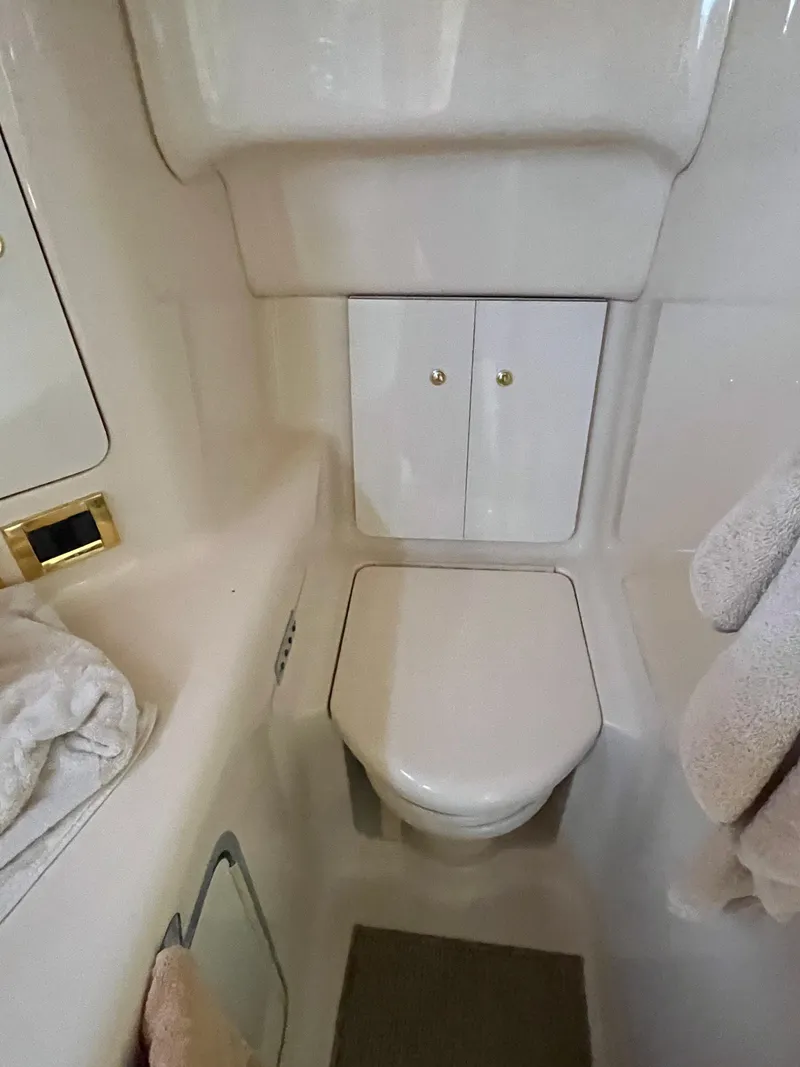 Slide: The Image of 1997 Sea Ray 420 Aft Cabin bathroom with toilet and storage cabinets. - 49