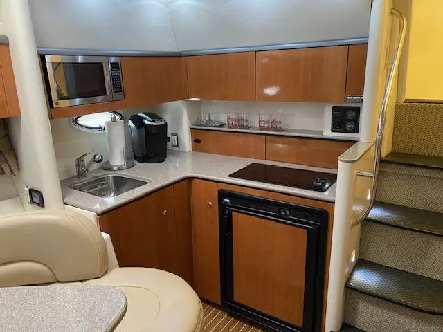 Slide: The Image of 2005 Maxum 3500 SY yacht interior kitchen with microwave, sink, and stove. - 11