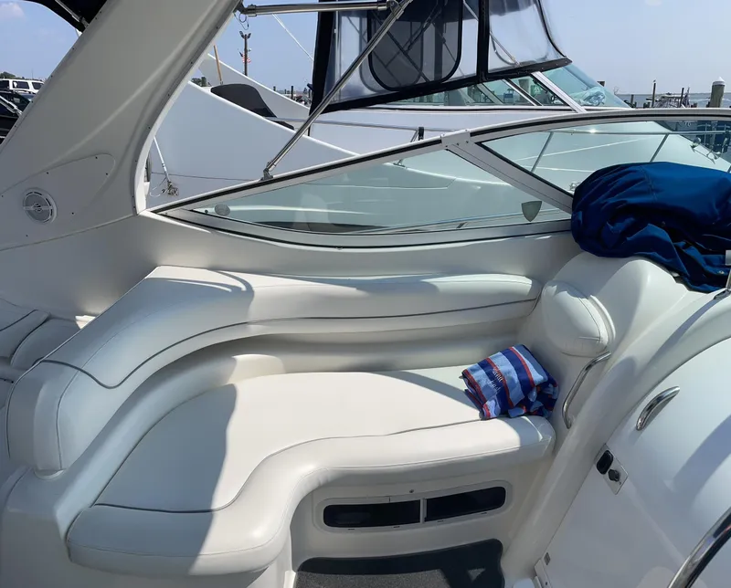 Slide: The Image of 2005 Maxum 3500 SY boat interior with white leather seating and striped towel. - 3