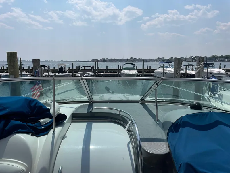 Slide: The Image of 2005 Maxum 3500 SY boat docked at a marina with a scenic waterfront view. - 4