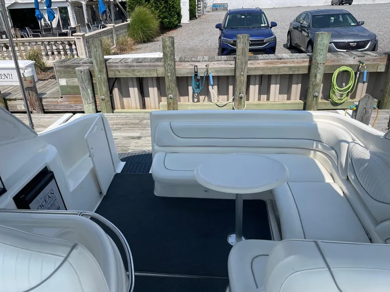 Slide: The Image of 2005 Maxum 3500 SY boat interior with white seating and table at dock. - 5