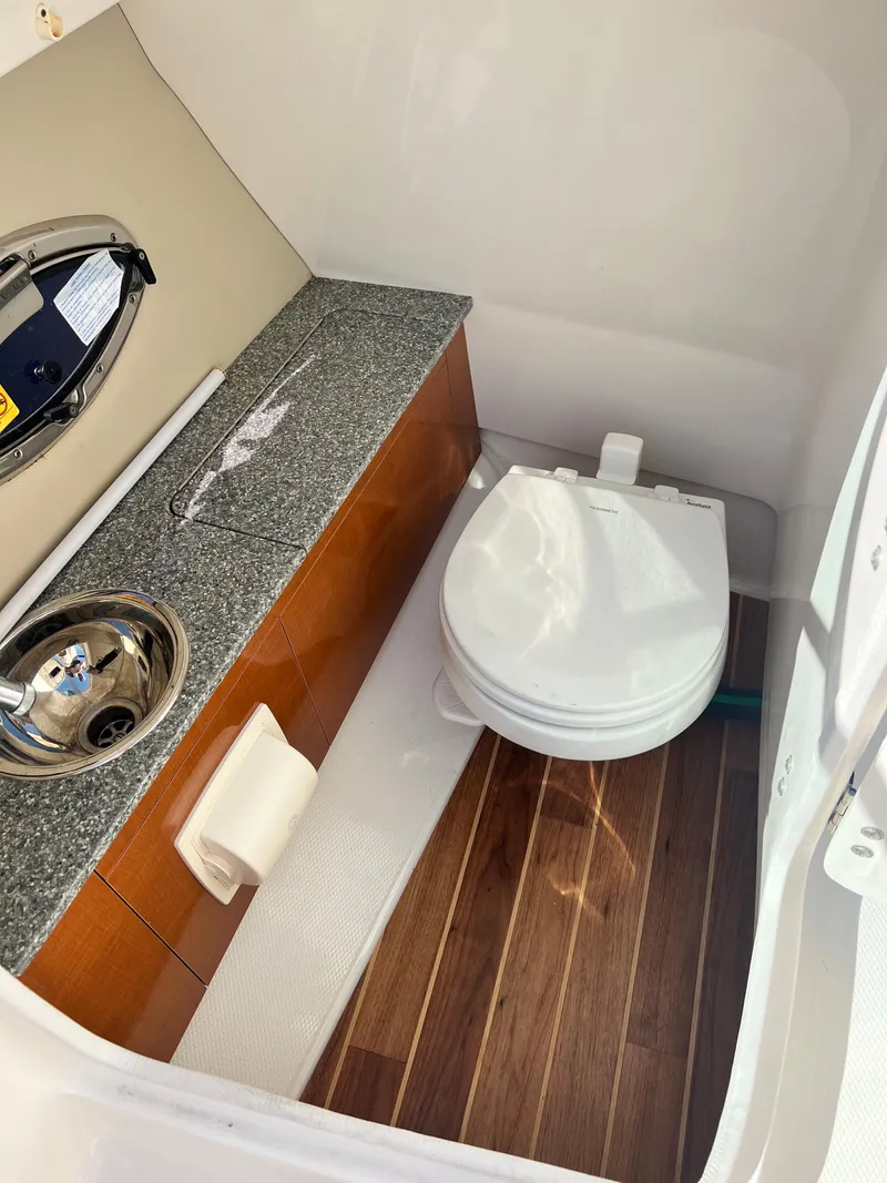 Slide: The Image of 2013 Chaparral 246 SSi boat interior bathroom with sink and toilet. - 13