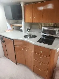 Slide: The Image of 2001 Formula 40 PC yacht kitchen with wooden cabinets, sink, stove, and microwave. - 14