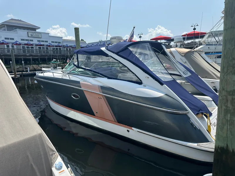 The Image of 2005 Cobalt 360 Cruiser docked at a marina with blue canopy. - 1