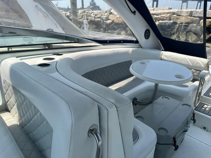 Slide: The Image of Interior seating area of a 2005 Cobalt 360 Cruiser with white upholstery and a small table. - 5