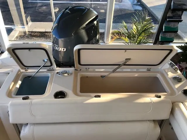 Slide: The Image of 2024 Grady-White Freedom 235 boat with open storage compartments and Yamaha 300 engine. - 11