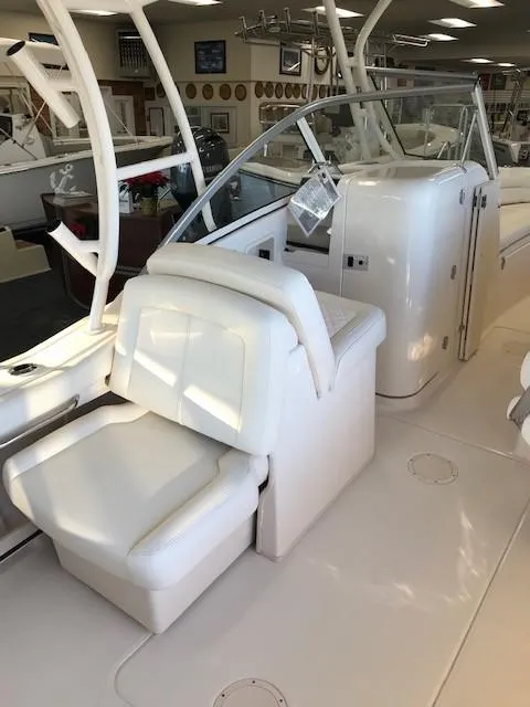 Slide: The Image of 2024 Grady-White Freedom 235 boat interior with white seating and helm station. - 7