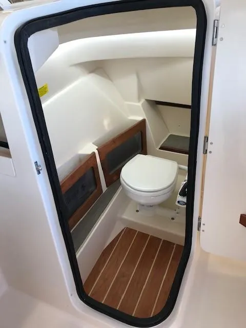 Slide: The Image of 2024 Grady-White Freedom 235 boat interior bathroom with wooden flooring. - 8