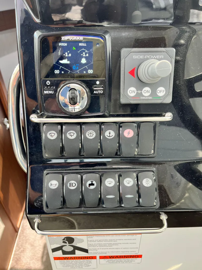 Slide: The Image of Control panel of 2022 Jeanneau NC 1095 boat with various switches and displays. - 10