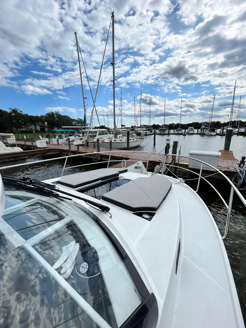 Slide: The Image of 2022 Jeanneau NC 1095 boat docked at marina under cloudy sky. - 11