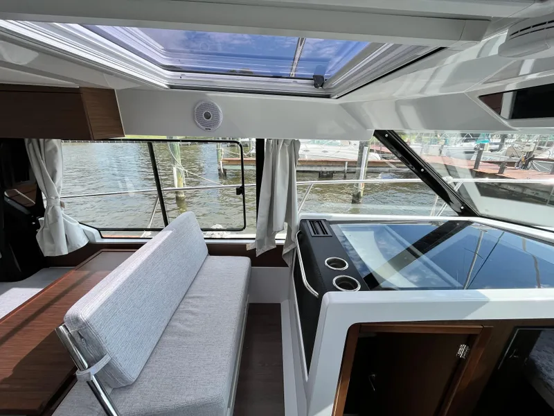 Slide: The Image of Interior of 2022 Jeanneau NC 1095 boat with modern seating and large windows. - 14