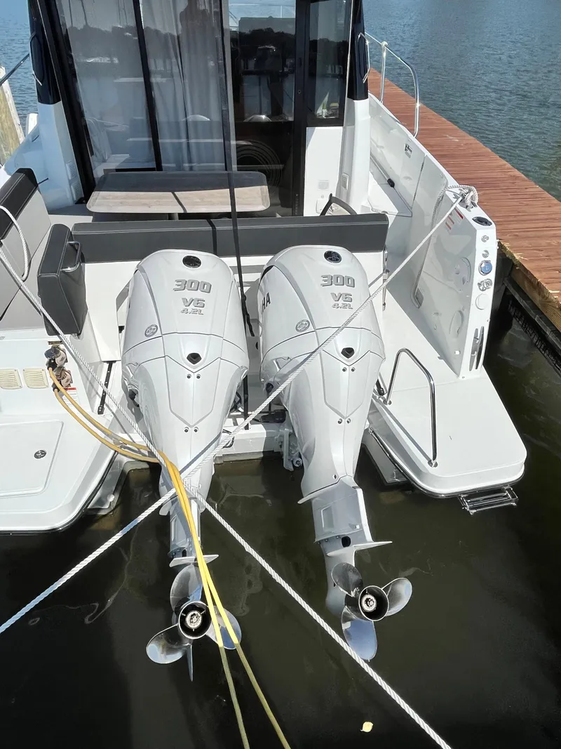 Slide: The Image of 2022 Jeanneau NC 1095 with twin 300 HP outboard engines docked at marina. - 18