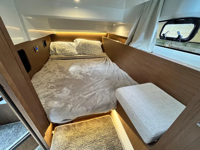 Slide: The Image of Cozy cabin interior of 2022 Jeanneau NC 1095 with plush bedding and ambient lighting. - 20