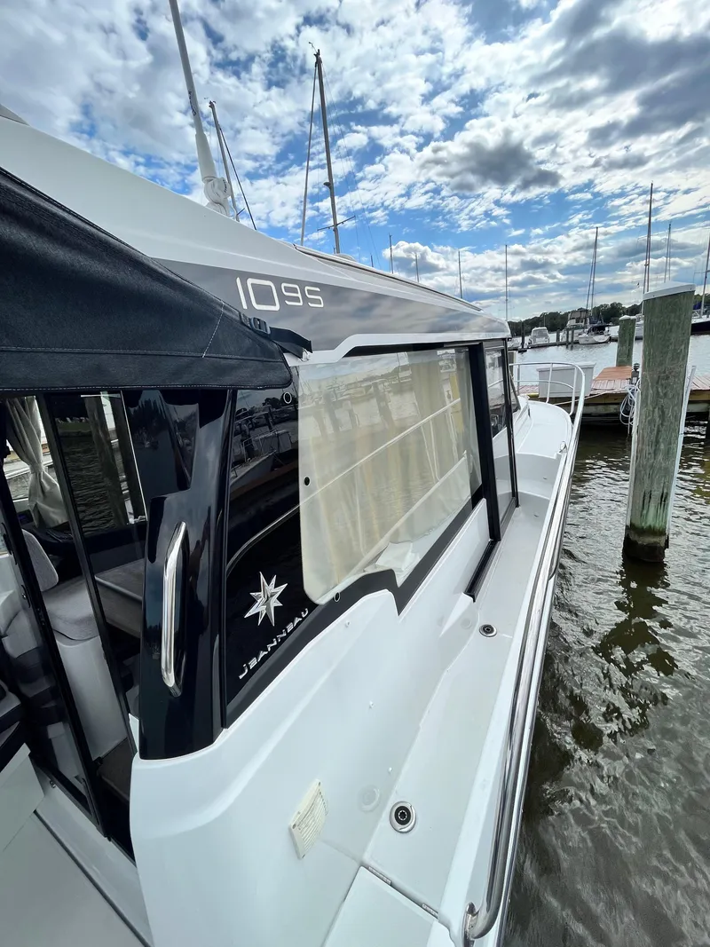 Slide: The Image of 2022 Jeanneau NC 1095 boat docked under cloudy sky. - 4