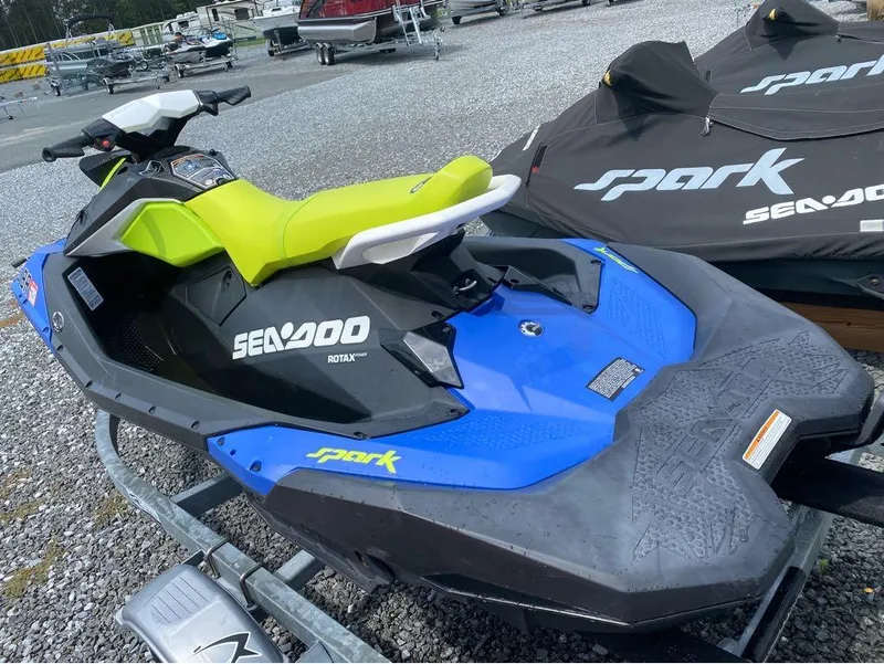 Slide: The Image of 2021 Sea-Doo SPARK 3 UP 90 with iBR, blue and green, parked on gravel. - 3