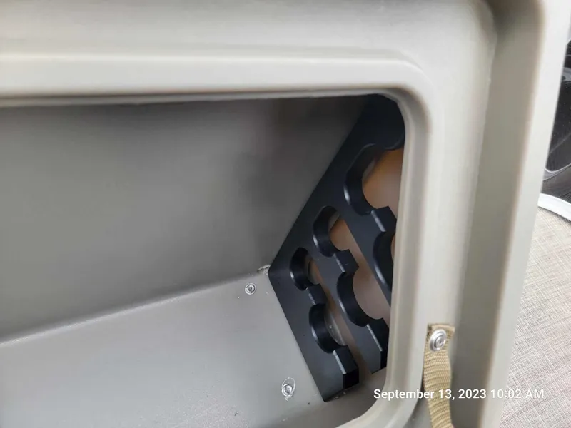 Slide: The Image of Storage compartment of 2024 Sun Tracker SportFish 22 DLX boat with rod holders. - 10