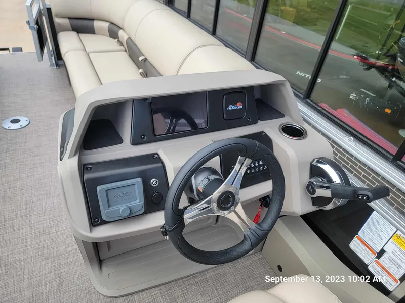 Slide: The Image of 2024 Sun Tracker SportFish 22 DLX boat dashboard with steering wheel and controls. - 22