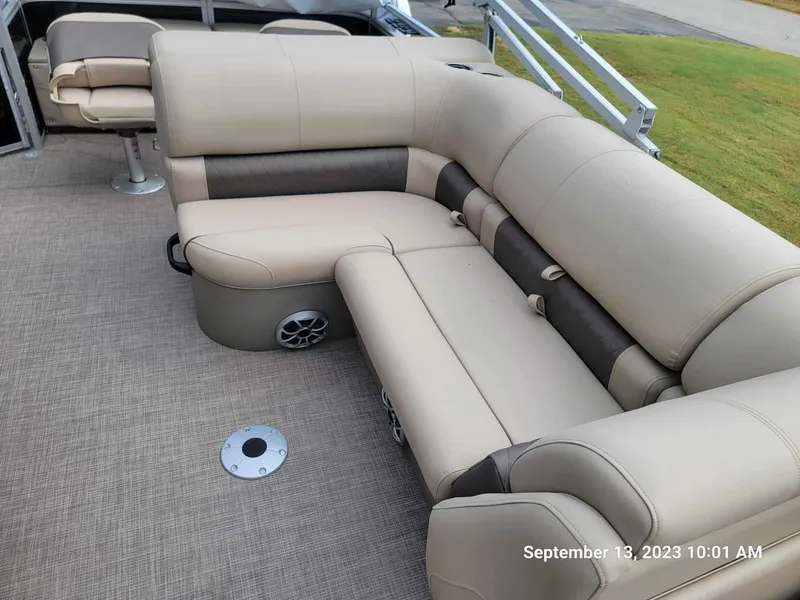 Slide: The Image of 2024 Sun Tracker SportFish 22 DLX pontoon boat with beige and brown seating. - 25