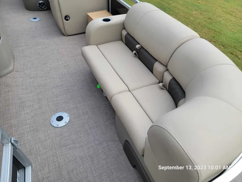 Slide: The Image of 2024 Sun Tracker SportFish 22 DLX boat interior with beige seating and carpet flooring. - 29