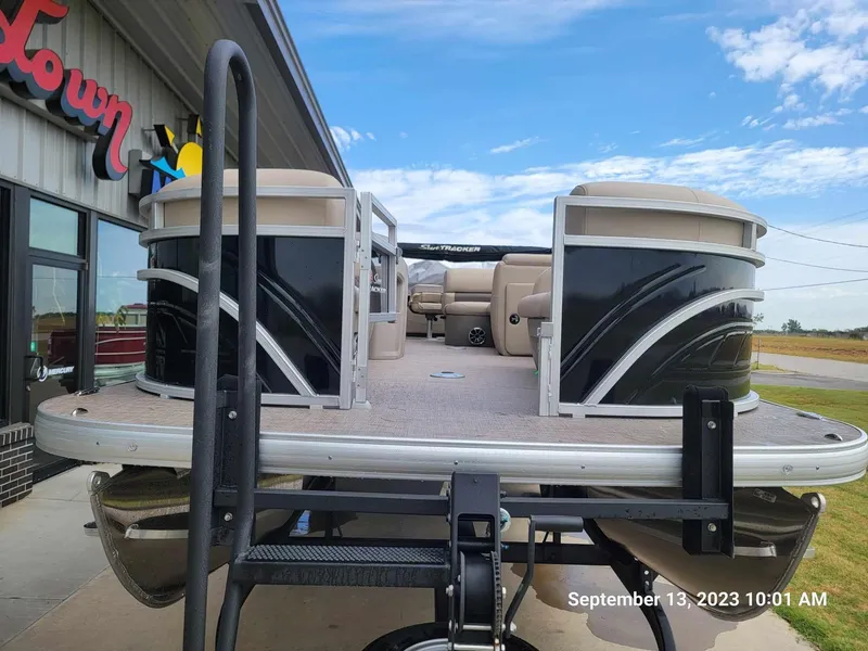 Slide: The Image of 2024 Sun Tracker SportFish 22 DLX pontoon boat at dealership, front view. - 7