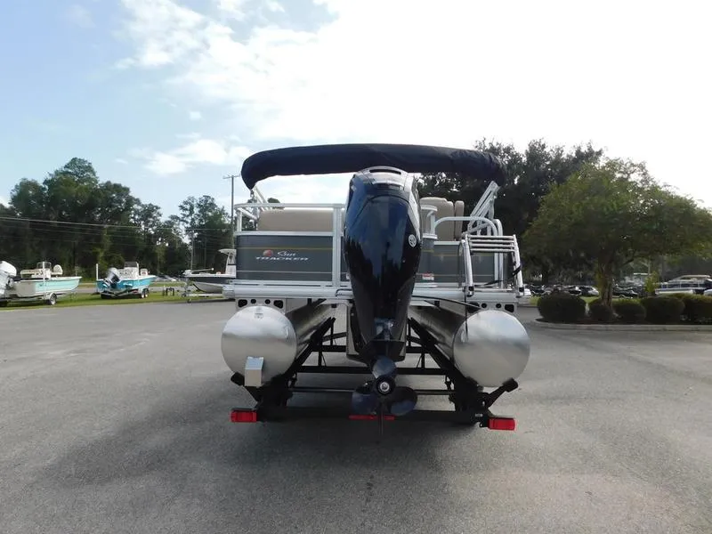 Slide: The Image of 2024 Sun Tracker Party Barge 18 DLX pontoon boat rear view in parking lot. - 5