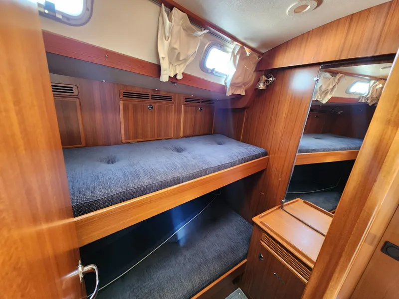 Slide: The Image of 2006 Hallberg-Rassy 53 yacht interior with wooden bunk beds and storage. - 12