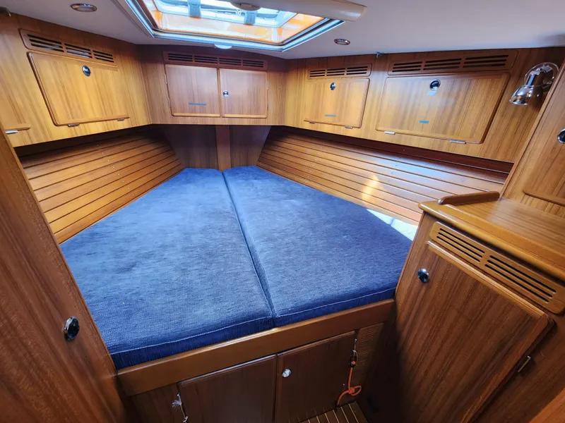 Slide: The Image of Interior cabin of 2006 Hallberg-Rassy 53 yacht with wooden finish and blue bedding. - 13