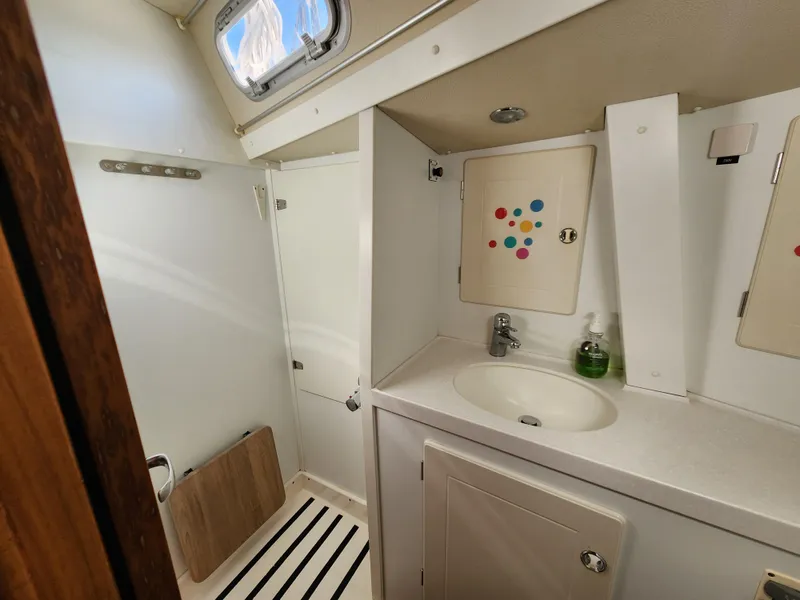 Slide: The Image of Bathroom interior of 2006 Hallberg-Rassy 53 yacht, featuring sink and storage cabinets. - 17