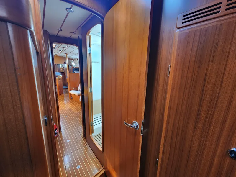 Slide: The Image of Interior view of 2006 Hallberg-Rassy 53 yacht, featuring wooden paneling and hallway. - 18