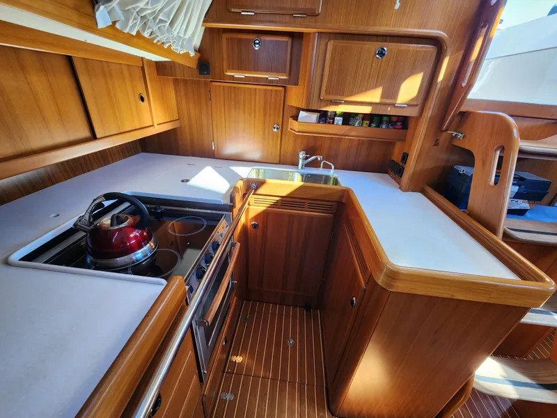 Slide: The Image of Luxurious 2006 Hallberg-Rassy 53 yacht kitchen with wooden cabinetry and modern appliances. - 20