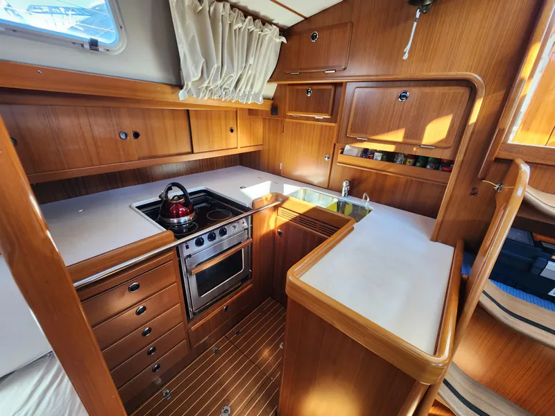Slide: The Image of Hallberg-Rassy 53 yacht kitchen interior, 2006 model, featuring wood cabinetry and modern appliances. - 21