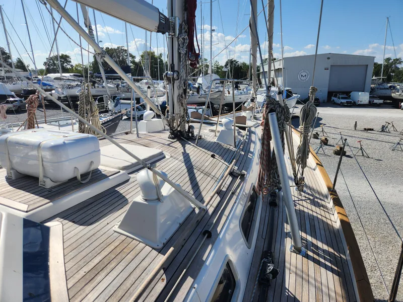 Slide: The Image of Deck view of a 2006 Hallberg-Rassy 53 sailboat in a marina setting. - 26