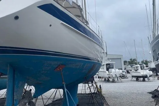 Slide: The Image of Hallberg-Rassy 53 sailboat from 2006 on dry dock, showcasing blue hull and white deck. - 42