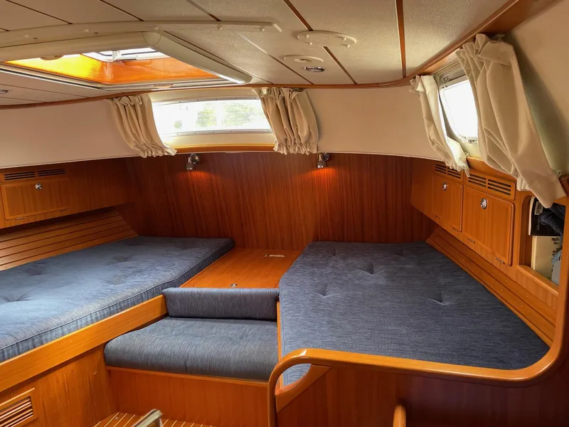 Slide: The Image of Interior of 2006 Hallberg-Rassy 53 sailboat with cozy wooden cabin and blue cushions. - 7
