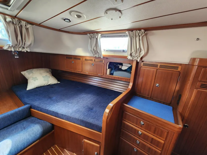 Slide: The Image of Cozy cabin interior of 2006 Hallberg-Rassy 53 yacht with wooden furnishings and blue bedding. - 8