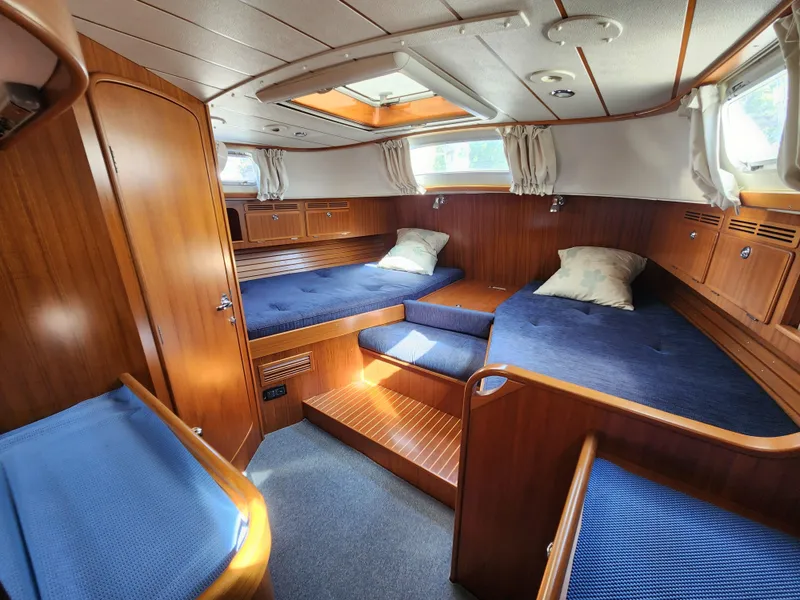 Slide: The Image of Luxurious 2006 Hallberg-Rassy 53 yacht cabin with wooden interior and blue upholstery. - 9