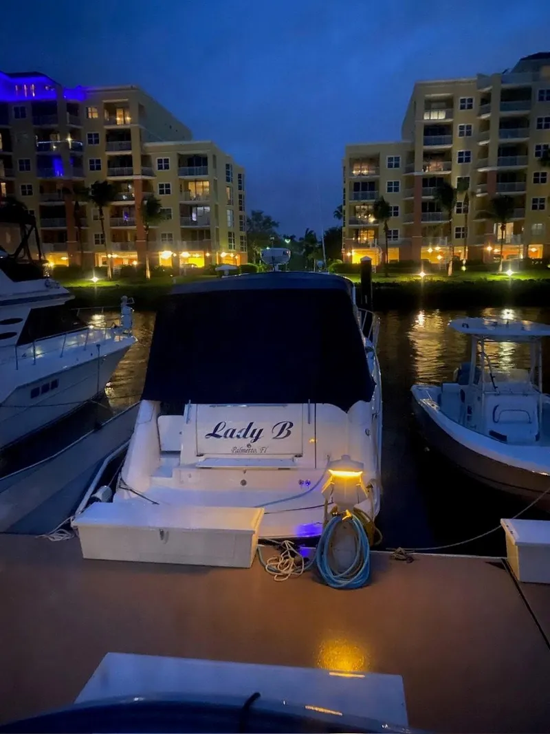 Slide: The Image of 2008 Rinker 350 Express Cruiser interior with wood flooring, cozy seating, and a well-appointed bed. - 12