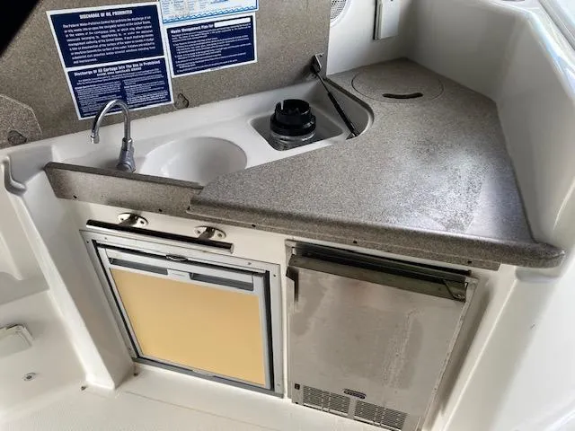 Slide: The Image of 2008 Rinker 350 Express Cruiser kitchenette with sink, stove, and mini-fridge. - 28