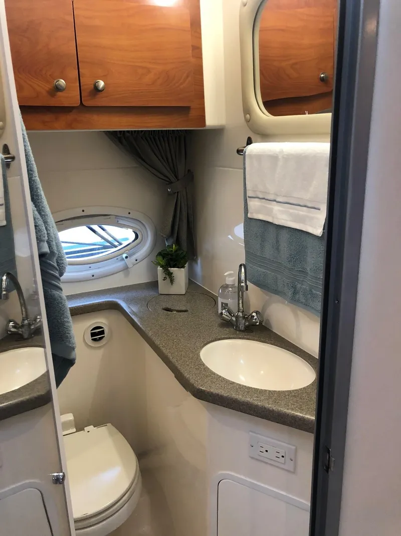 Slide: The Image of 2008 Rinker 350 Express Cruiser kitchen with microwave, TV, and wooden cabinetry. - 8