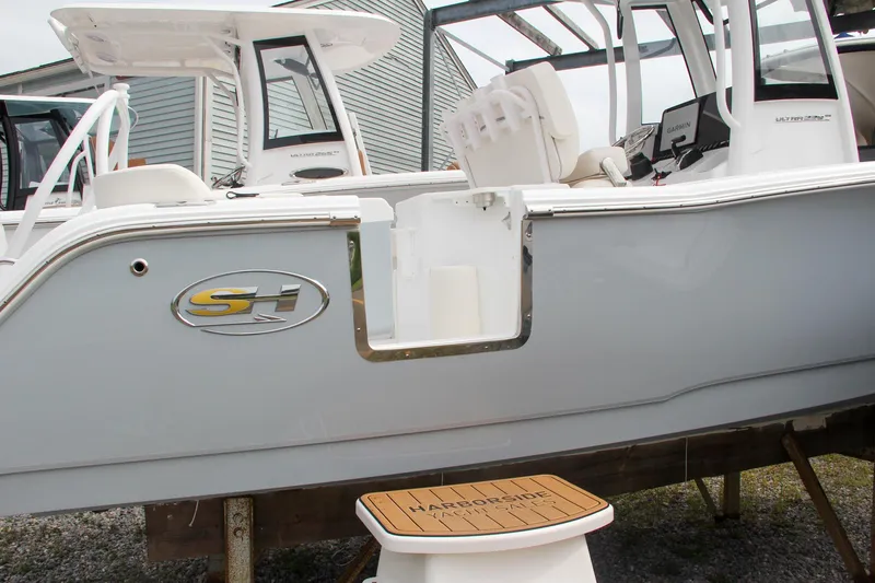 Slide: The Image of 2024 Sea Hunt Ultra 239 SE boat side view with open door. - 2