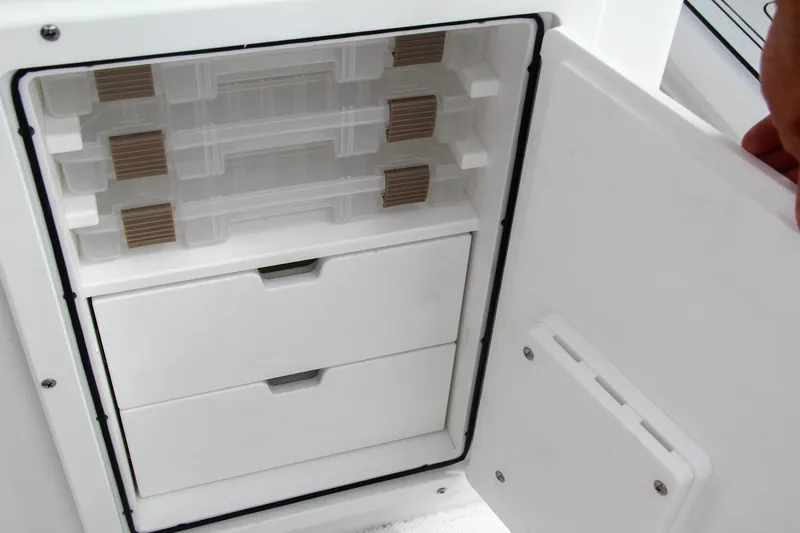 Slide: The Image of 2024 Sea Hunt Ultra 239 SE storage compartment with drawers and tackle boxes. - 24