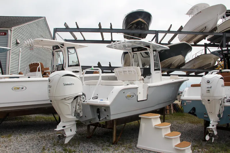 Slide: The Image of 2024 Sea Hunt Ultra 239 SE boat on display at a marina. - 3
