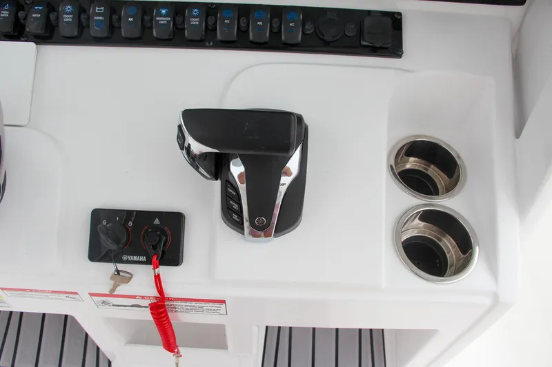 Slide: The Image of 2024 Sea Hunt Ultra 239 SE control panel with throttle and cup holders. - 30