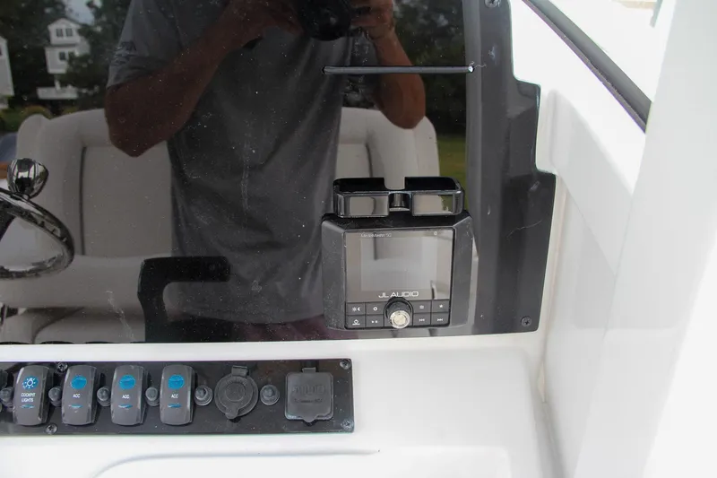 Slide: The Image of Control panel of 2024 Sea Hunt Ultra 239 SE boat with switches and display. - 33