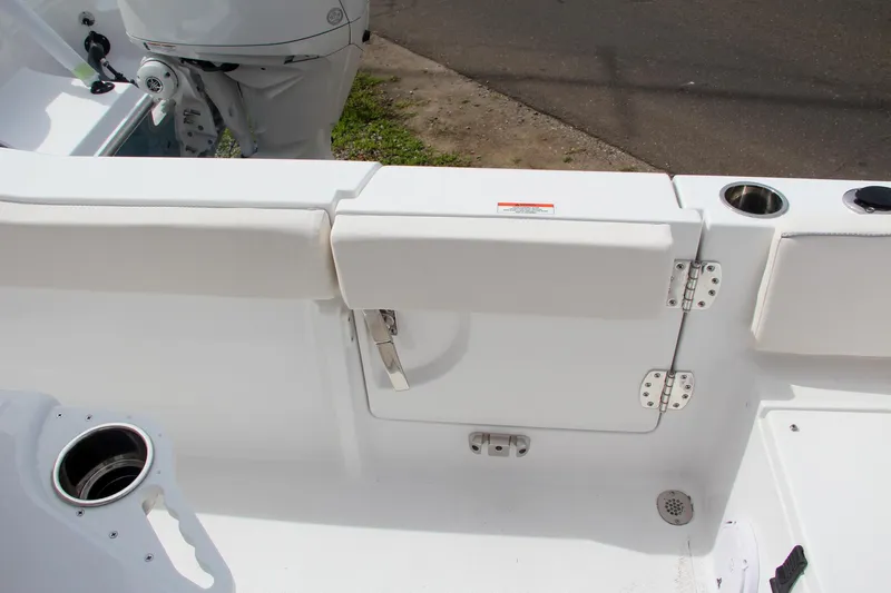 Slide: The Image of 2024 Sea Hunt Ultra 239 SE boat interior with white cushioned seating and storage compartment. - 6
