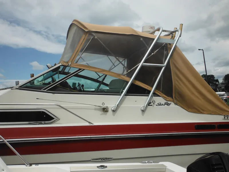 Slide: The Image of 1988 Sea Ray 268 Sundancer boat with tan canopy and red stripe. - 15