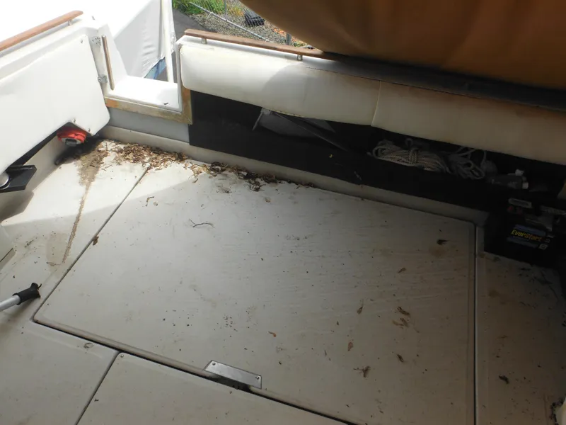 Slide: The Image of 1988 Sea Ray 268 Sundancer boat interior with dirty floor and storage compartments. - 16