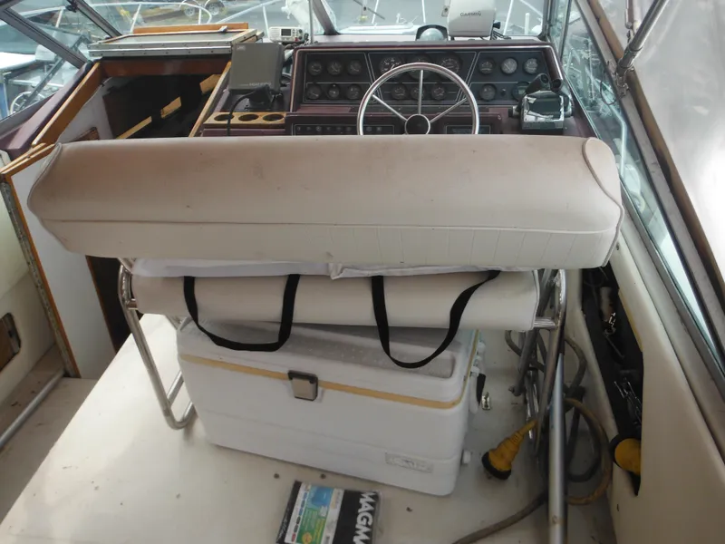 Slide: The Image of 1988 Sea Ray 268 Sundancer helm with white captain's seat and cooler. - 17