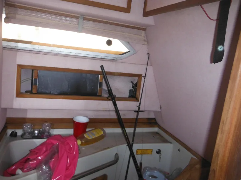 Slide: The Image of Interior cabin of 1988 Sea Ray 268 Sundancer with fishing rods and clutter. - 31